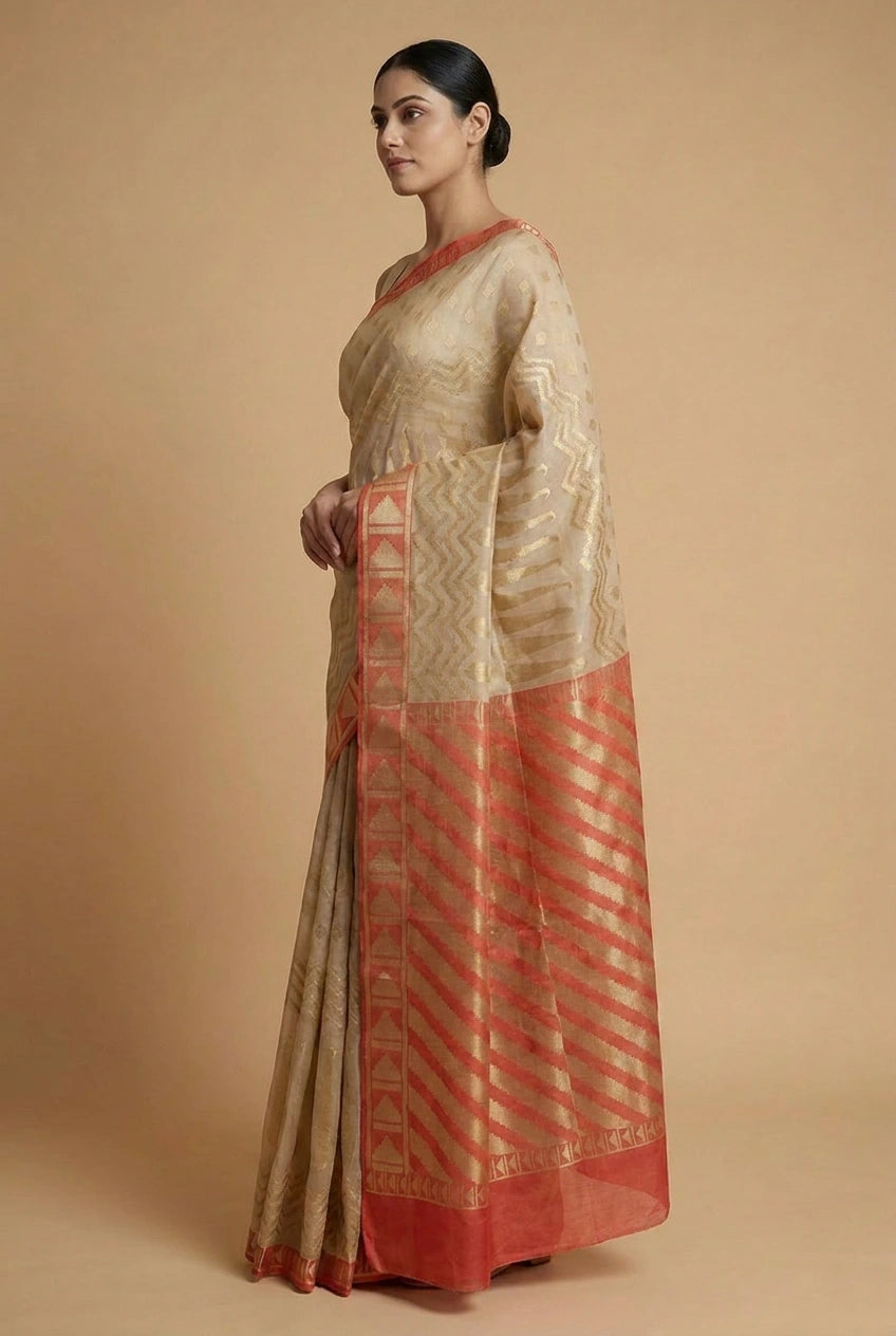 Woman wearing a traditional saree with a beige and red pattern on a beige background