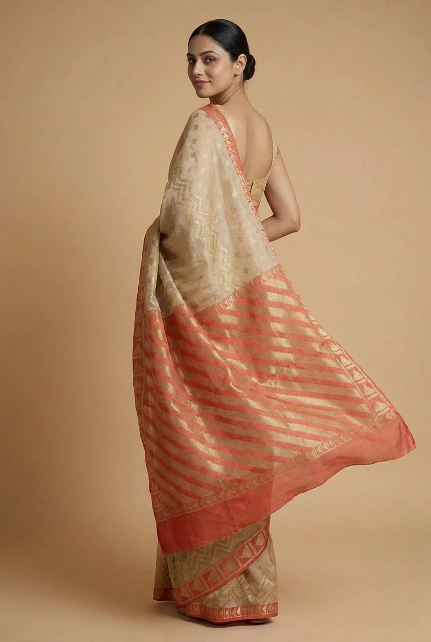 Woman wearing a beige and red saree against a beige background