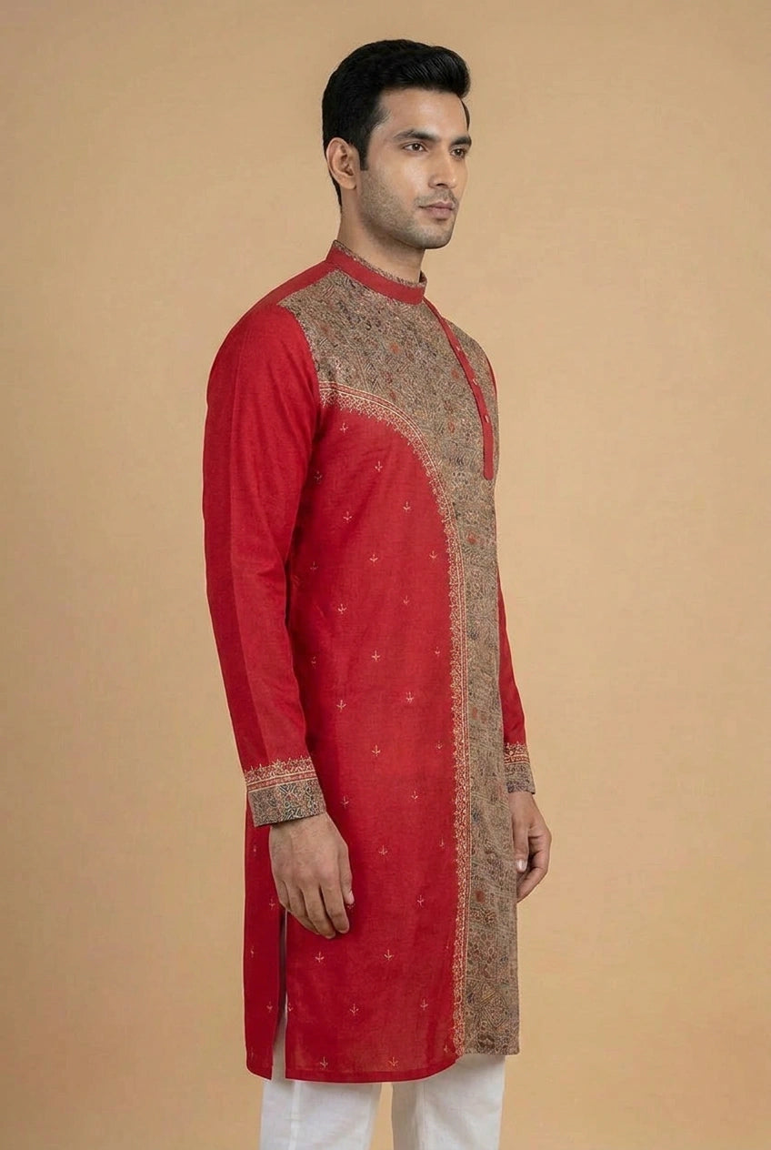 Man wearing a red kurta with intricate patterns on a beige background