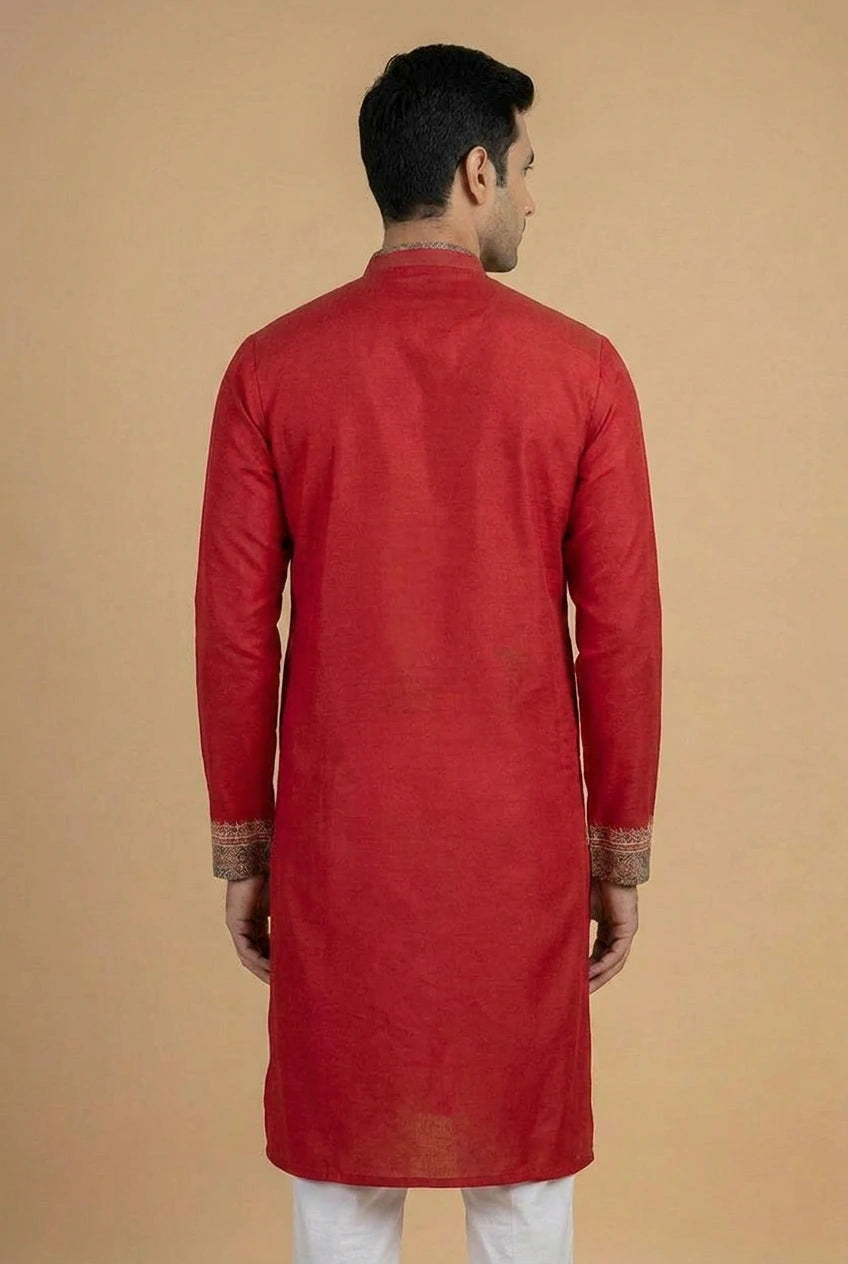 Man wearing a red kurta against a beige background