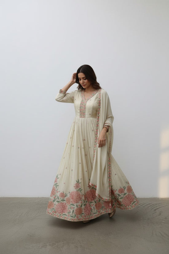 Rangoli cream Anarkali suit with floral embroidery on neckline, sleeves, and hem. Includes matching dupatta.