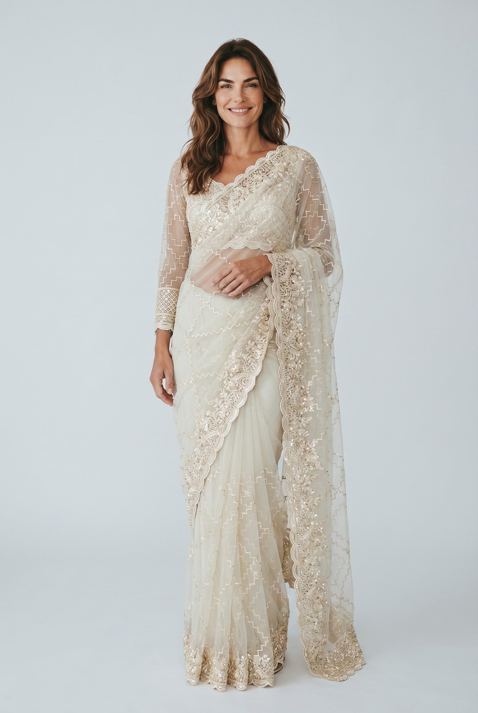 Rangoli cream net saree with gold embroidery, sequins, and full sleeves. Features a detailed border and matching dupatta.