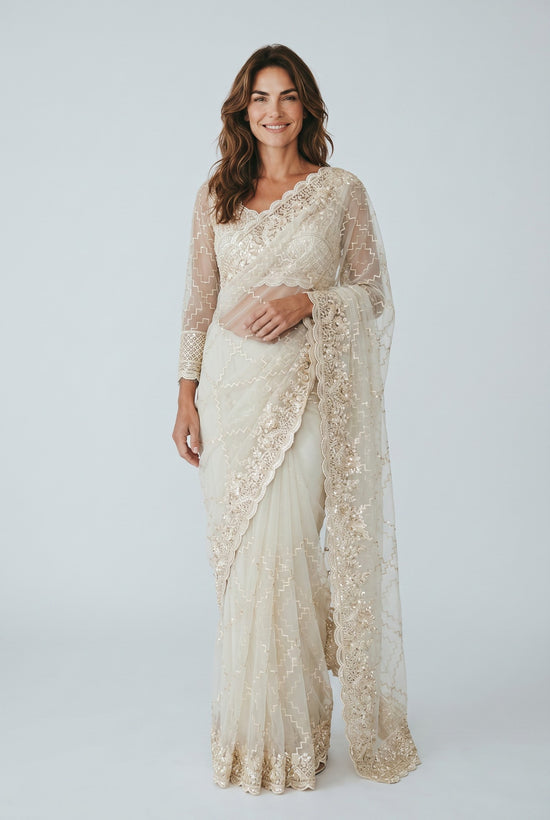 Rangoli cream net saree with gold embroidery, sequins, and full sleeves. Features a detailed border and matching dupatta.