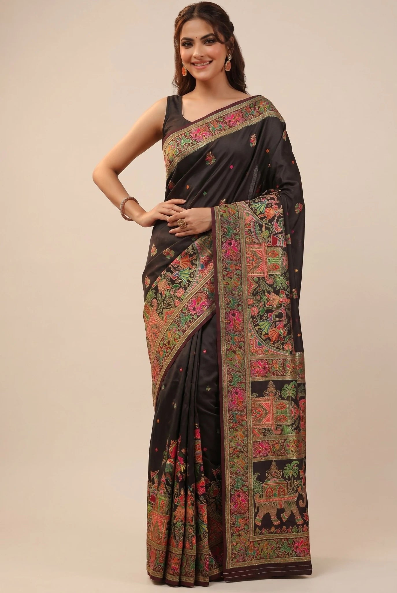 Woman wearing a black saree with colorful patterns on a beige background