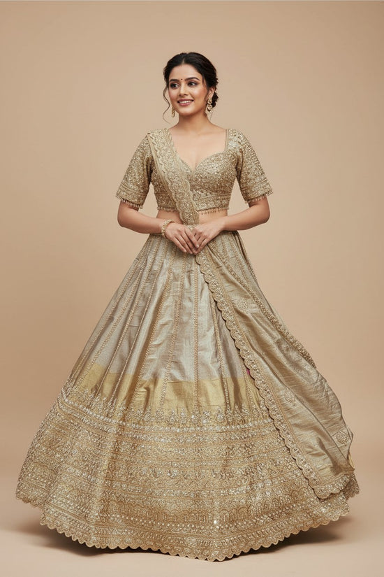 Rangoli golden silk lehenga with intricate embroidery and embellishments, includes blouse and dupatta.
