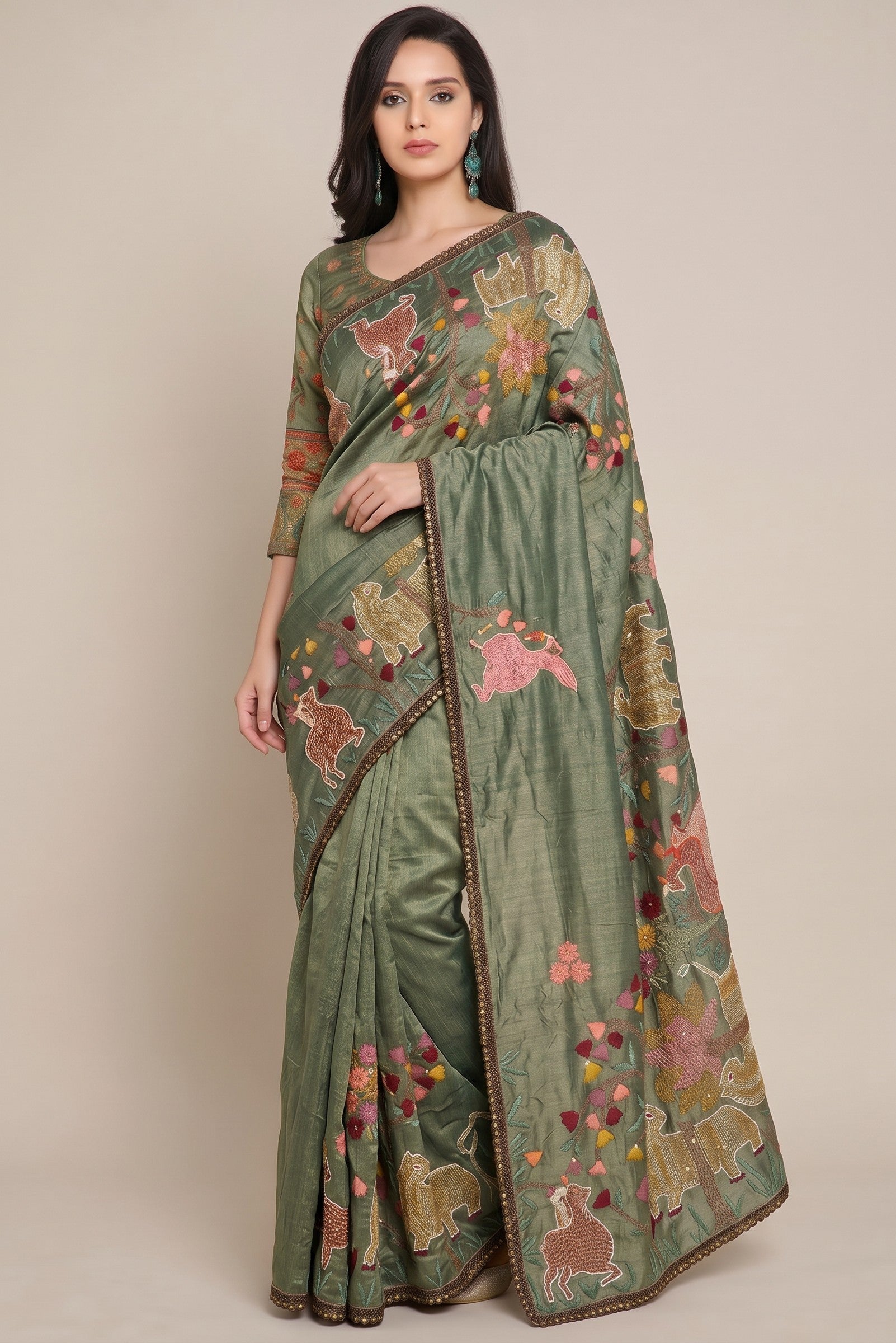 Rangoli olive green silk blend saree with colorful animal and floral embroidery, and a delicate border. Model wears a matching blouse.