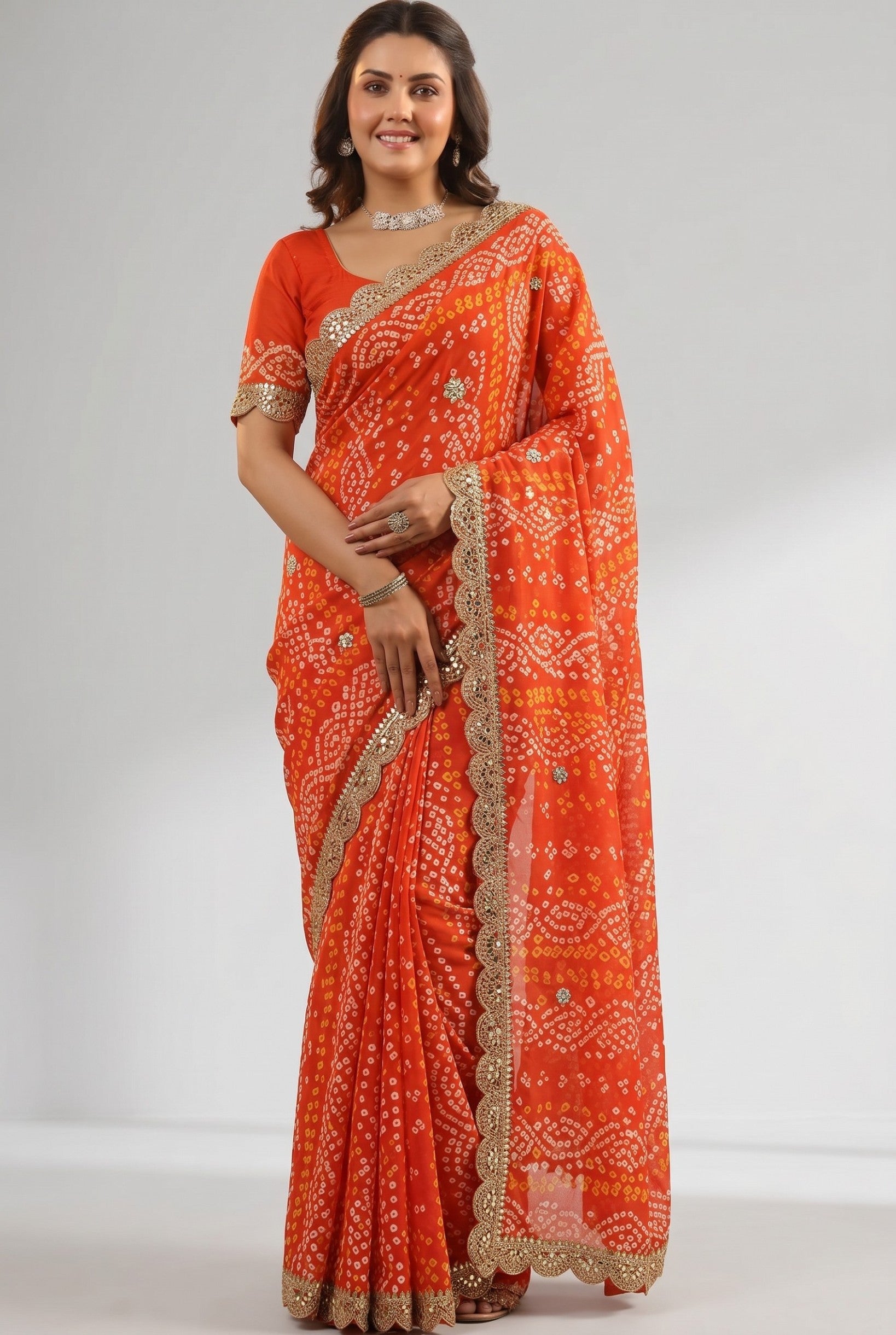 Rangoli orange georgette bandhani saree with white and yellow tie-dye pattern, sequin border, and lace trim. Model wears it for a festive occasion.