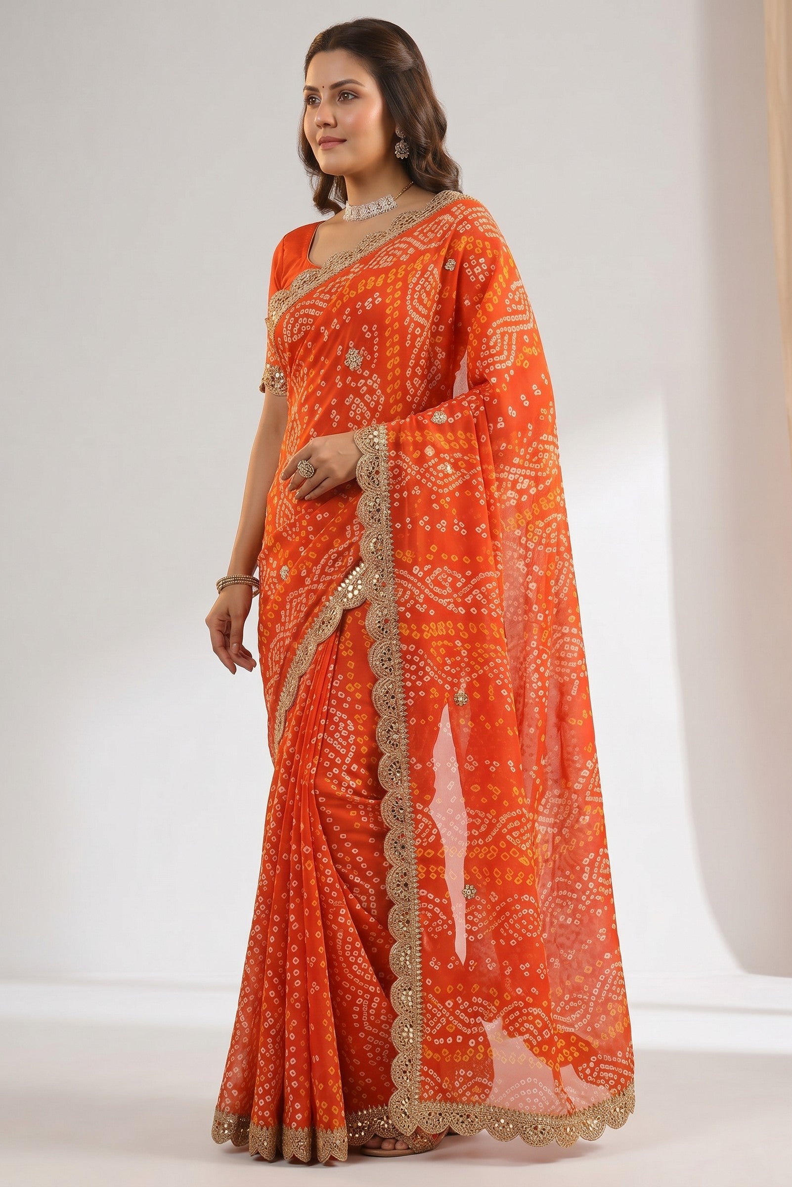 Rangoli orange georgette bandhani saree with white and yellow tie-dye pattern, sequin border, and lace trim.