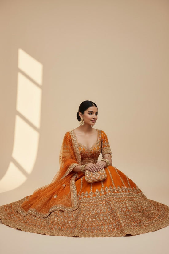 Rangoli orange silk lehenga with gold embroidery, beadwork, and net dupatta. Traditional Indian attire for celebrations.