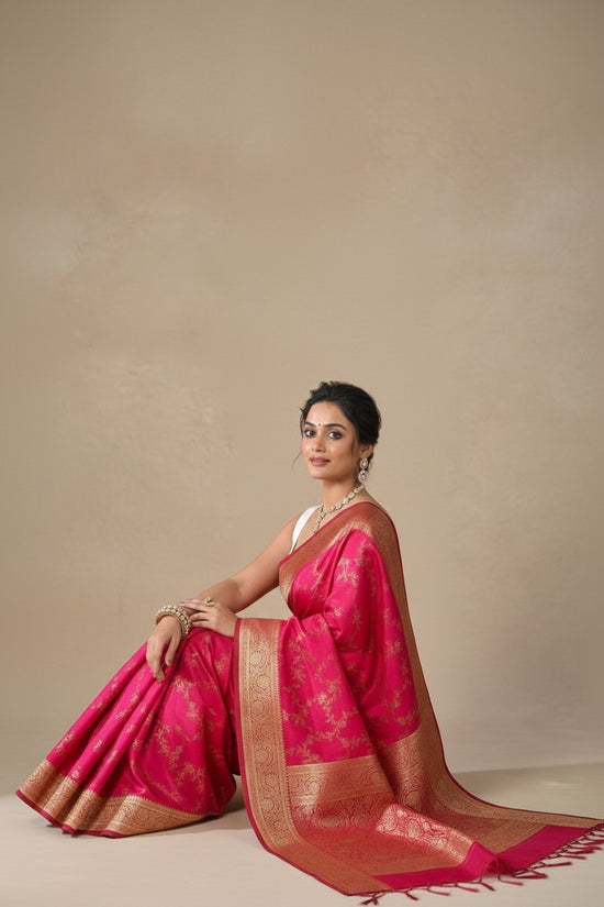 Rangoli pink silk brocade saree with golden zari weaving and traditional motifs. Perfect for festive occasions.