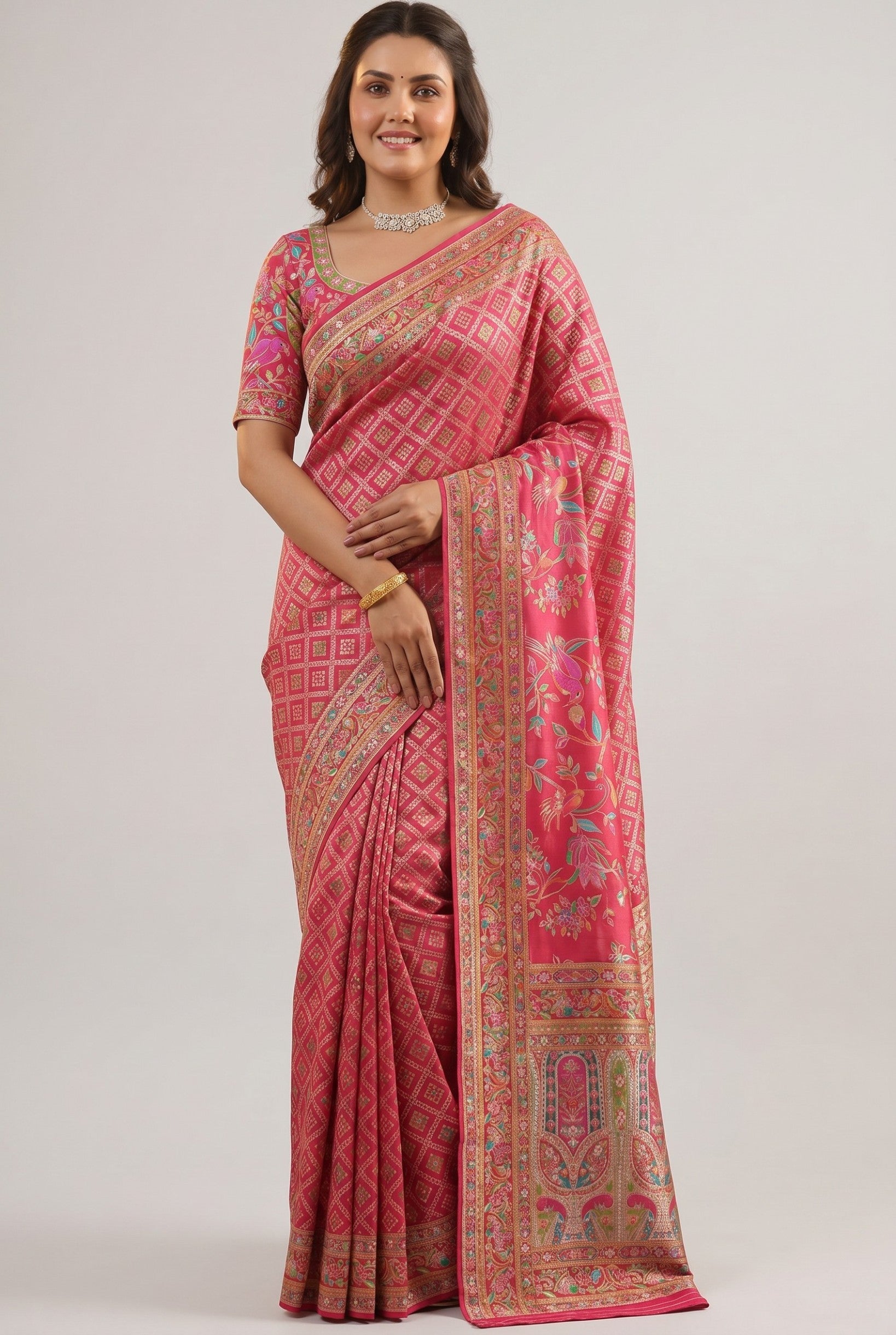 Rangoli pink silk saree with diamond pattern, floral border, and intricate weaving. Model wears a matching blouse and jewelry.