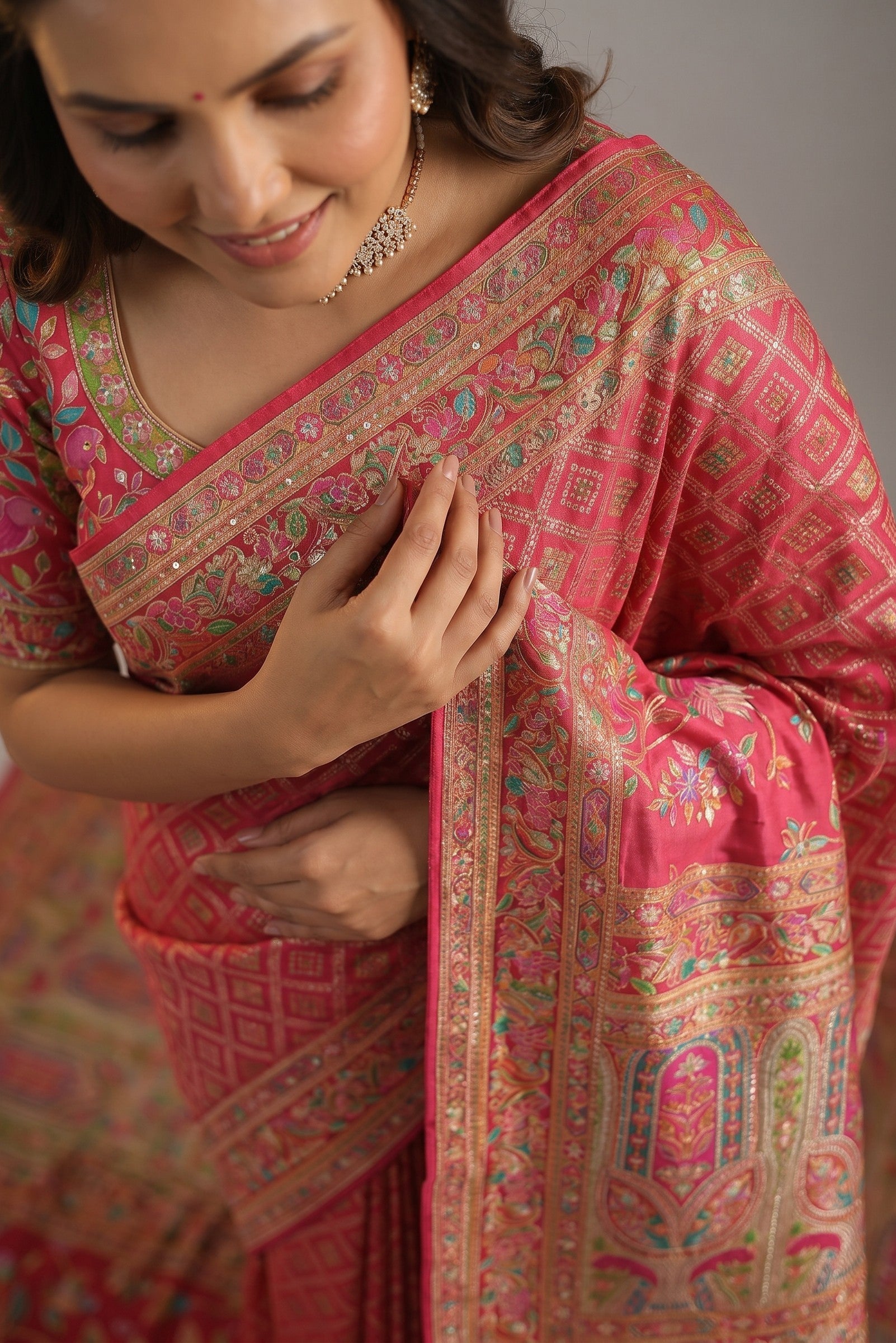 Rangoli pink silk saree with intricate floral border and diamond pattern. Luxurious fabric perfect for special occasions.