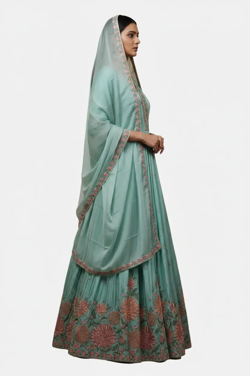 Woman wearing a light green traditional outfit with a matching dupatta on a white background