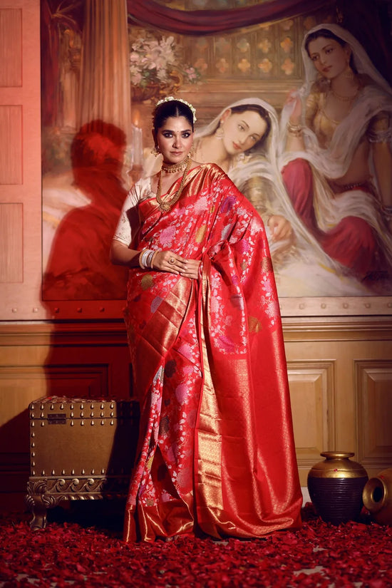Woman in a red saree standing in front of a classical painting